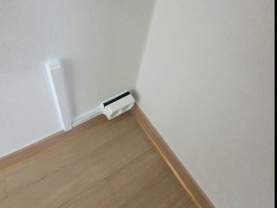 몰딩으로 마감한 바닥 모서리 2구 콘센트